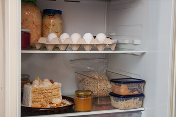Inside view of a refrigerator stocked with various food items and leftovers