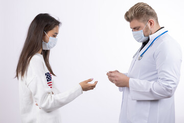 Doctors in medical masks looking at smartphone screen and discussing data