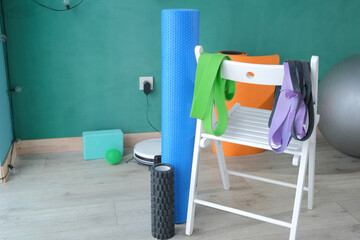 fitness rubber band and set of massage rolls, fitness equipment or interior on floor at home
