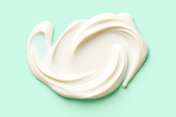 Smooth Swirl of White Cosmetic Skincare Cream or Moisturizing Lotion on a Mint Green Surface