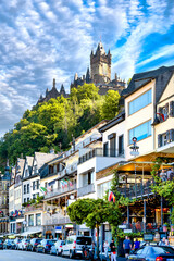 City view of Cochem with busy street in summer and castle on the hill