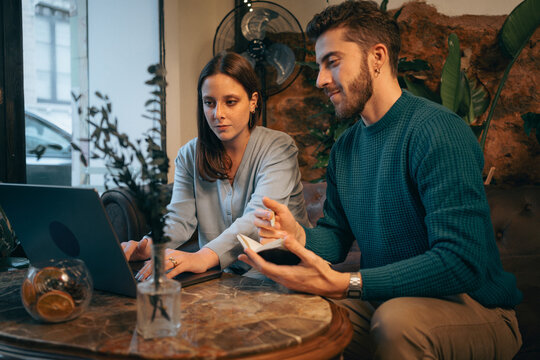 Young couple working together on laptop, collaboration and planning at home - Powered by Adobe