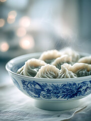 Freshly steamed dumplings in a traditional Chinese blue and white porcelain bowl