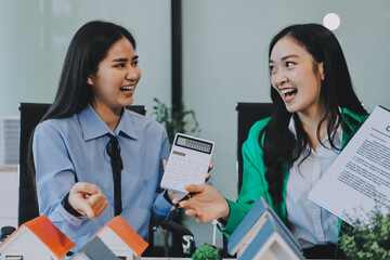 Professional real estate agents brainstorming house project while planning home investment with architectural model and documents