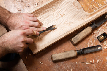 The master processes the tagelharpa billet with a chisel