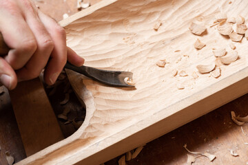 The master works with a chisel, making talharpa