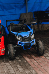 A photograph of many colorful children's plastic cars and toys parked in a rental park.