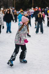 Beautiful happy smiling teenage girl, child skating on ice rink in winter outdoors.