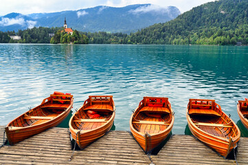 Wooden boats and Pilgrimage Church of the Assumption of Maria,Lake Bled,summer season