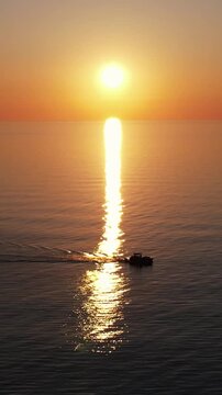 Calm Ocean Sunset with Shimmering Sun Path. Boat sails through the sunset.
