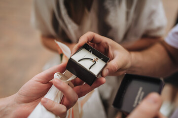 A photograph of a gold jewelry cross in a box as a gift from a person on the Christian holiday of baptism.