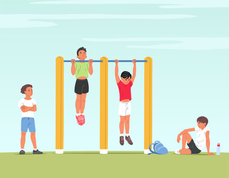 School boys doing pull ups on playground bars