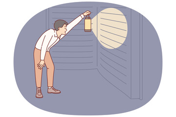 Man reads giant book with interest, holding lantern to illuminate encyclopedia at night