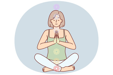 Woman practices yoga sitting in lotus position to cleanse aura and activate chakras