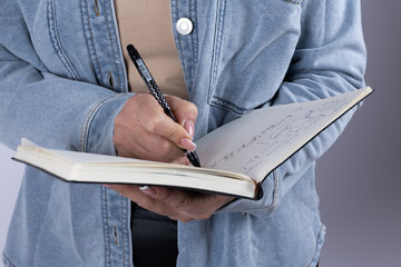 Woman writing in notebook close up