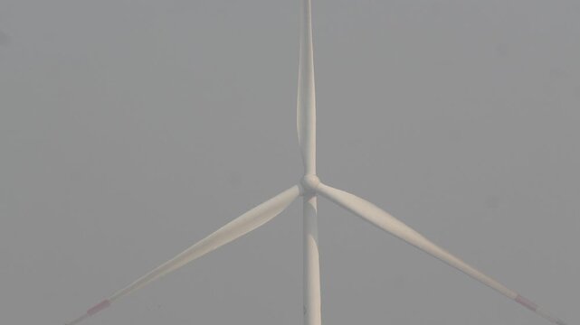 Wind Turbine Converting Wind Energy into Electrical Power in 120fps 4K Slow Motion. Renewable Energy Generator with Rotating Blades Against Open Sky, Clean Sustainable Power Concept Captured in Cinema
