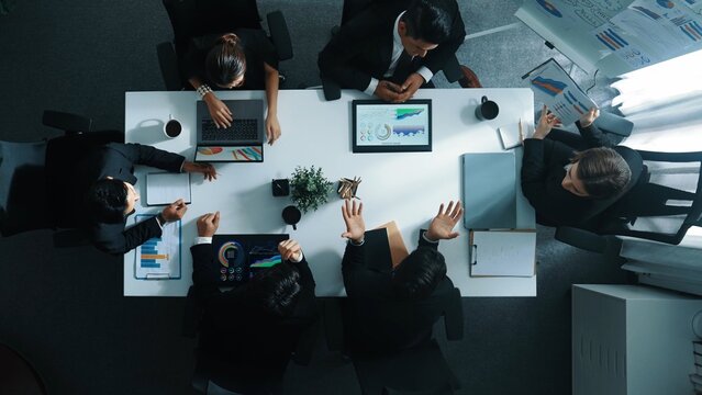 Top down aerial view of investor handed financial document to manager while explain marketing idea at meeting table. People looking at growing graph while listen business team discussion. Directorate.