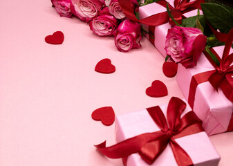 Beautiful and festive background for valentines day or anniversary celebration in pink with pink present and red ribbons roses and copy space