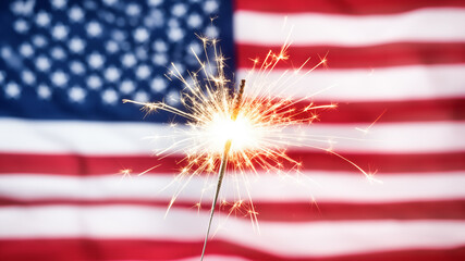 Sparkler burning beside the American flag symbolizing celebration, freedom and patriotism. Perfect for Independence Day designs.