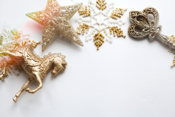 Gold Christmas ornaments&mdash;star, candy, key and horse&mdash;arranged on a clean white background with copy space. Elegant festive flat lay for holiday design and advertising.