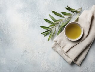 food background with linen napkin, olive branch and olive oil on concrete surface, top view
