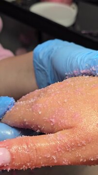 anti-aging hand peeling and massage treatment in spa salon. Skincare and rejuvenation Vertical close-up video. spa therapist performs an exfoliating scrub and gentle massage on a woman's hands