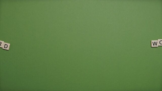 Stop Motion Animation of Wooden Tiles Spelling Hard Work Text on Green Background Concept