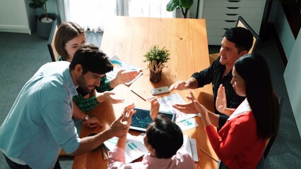 Top view of happy creative team putting hands together while drawing mind map. Group of diverse people working together brainstorming marketing idea and sharing plan by using sticky notes. Convocation