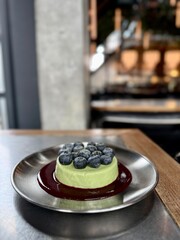 Green Matcha Cheesecake with Fresh Blueberries and Berry Sauce