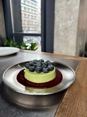 Green Matcha Cheesecake with Fresh Blueberries and Berry Sauce