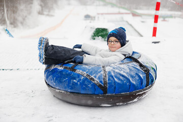 Child Enjoying Snow Tubing Adventure on a Winter Day