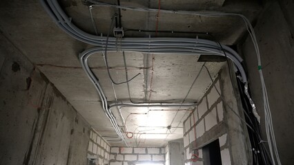 Electrical wiring conduits installing on concrete ceiling
