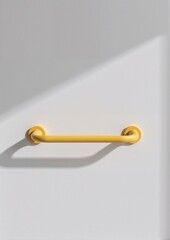 Yellow door handle on a white wall casting a shadow