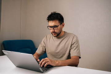 Portrait of successful programmer male working typing code on laptop keyboard, showcasing process of software development and coding expertise. Concept of remote workplace.