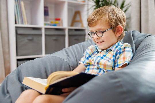 Smiling Child Reading a Book in Cozy Home Setting