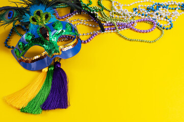 Top view of a beautiful composition of colorful masks, confetti, Mardi Gras decorations. Yellow Mardi Gras banner.