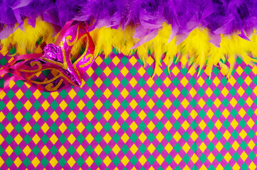 Top view of a beautiful composition of colorful masks, confetti, Mardi Gras decorations. Yellow Mardi Gras banner.