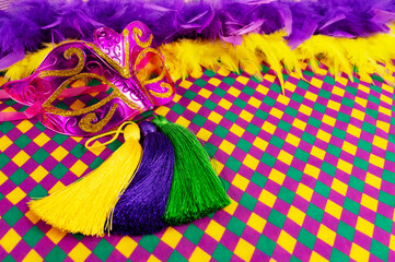 Top view of a beautiful composition of colorful masks, confetti, Mardi Gras decorations. Yellow Mardi Gras banner.