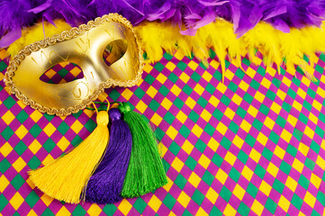 Top view of a beautiful composition of colorful masks, confetti, Mardi Gras decorations. Yellow Mardi Gras banner.