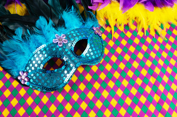 Top view of a beautiful composition of colorful masks, confetti, Mardi Gras decorations. Yellow Mardi Gras banner.