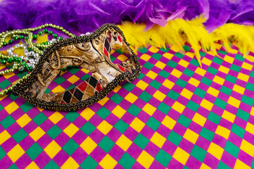 Top view of a beautiful composition of colorful masks, confetti, Mardi Gras decorations. Yellow Mardi Gras banner.