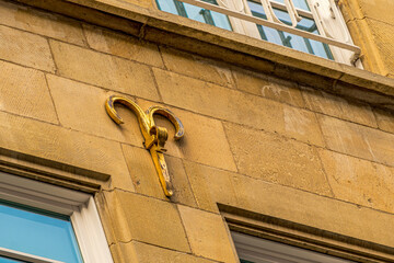 A gold-colored roman numeral is attached to a brown brick wall in Muenster Germany