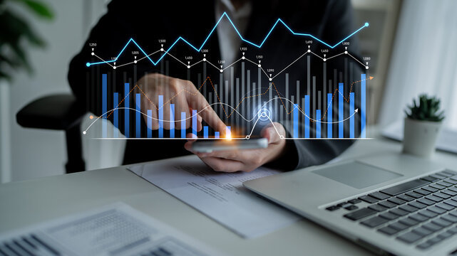 A business professional engages with financial data using a smartphone while an interactive digital graph displays trends, highlighting analysis in a modern office space. Scalp - Powered by Adobe