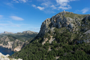 Obraz premium Rocky cliffs and lush greenery under a blue sky.. Palma de Mallorca, Spain