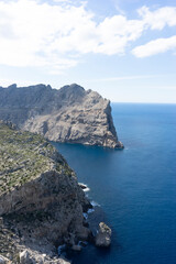 Coastal cliffs overlooking a blue sea under a cloudy sky.. Palma de Mallorca, Spain