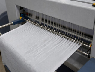 Close-up of a high-speed industrial knitting machine producing seamless athletic fabric with a breathable mesh pattern