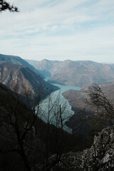View of Perucac Lake stretching through mountain canyon from rocky viewpoint in Tara National Park, Serbia. Dramatic natural landscape with steep slopes.