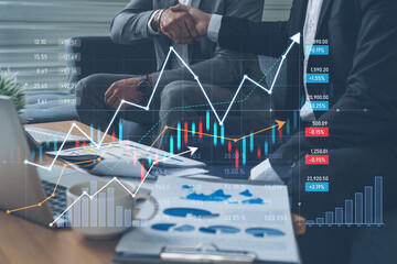 Two business professionals shake hands to seal a partnership, surrounded by digital financial data and graphs illustrating market trends for strategic growth. Scalp