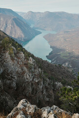 View of Perucac Lake stretching through mountain canyon from rocky viewpoint in Tara National Park, Serbia. Dramatic natural landscape with steep slopes.