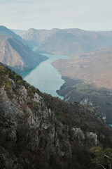 View of Perucac Lake stretching through mountain canyon from rocky viewpoint in Tara National Park, Serbia. Dramatic natural landscape with steep slopes.